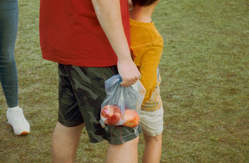 woman in red tank top holding plastic bag