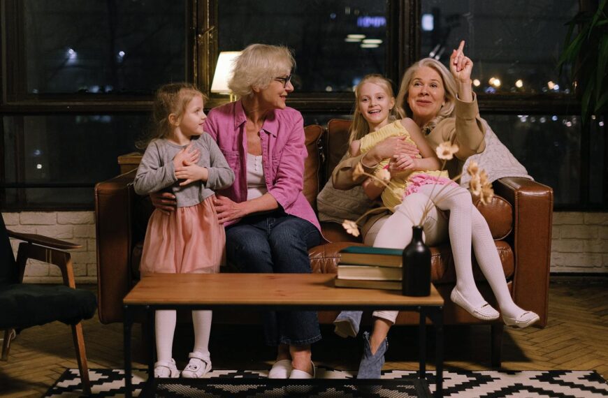 Two grandmothers enjoy quality time with their granddaughters indoors.