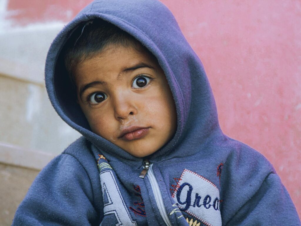 Captivating close-up of a child in a hoodie showing a curious expression.