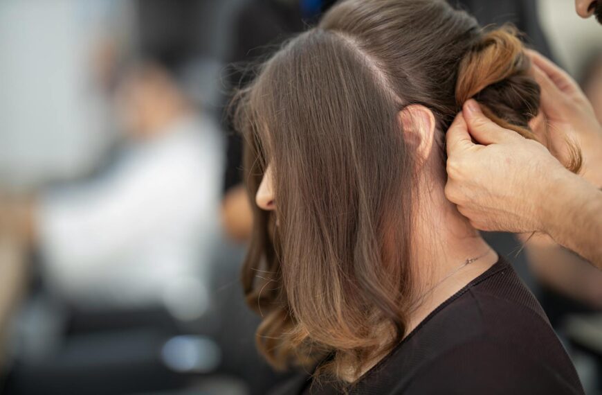 Close-up of a hairstylist creating an elegant hairstyle for a woman in a salon.