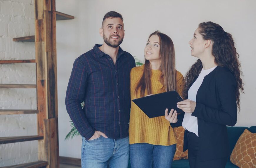 Young couple exploring a new home with their real estate agent, discussing options and features.
