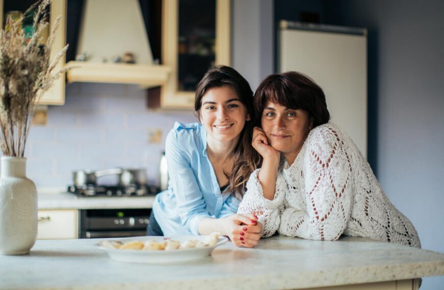 A mother and daughter bonding in the kitchen, smiling and enjoying their time together.