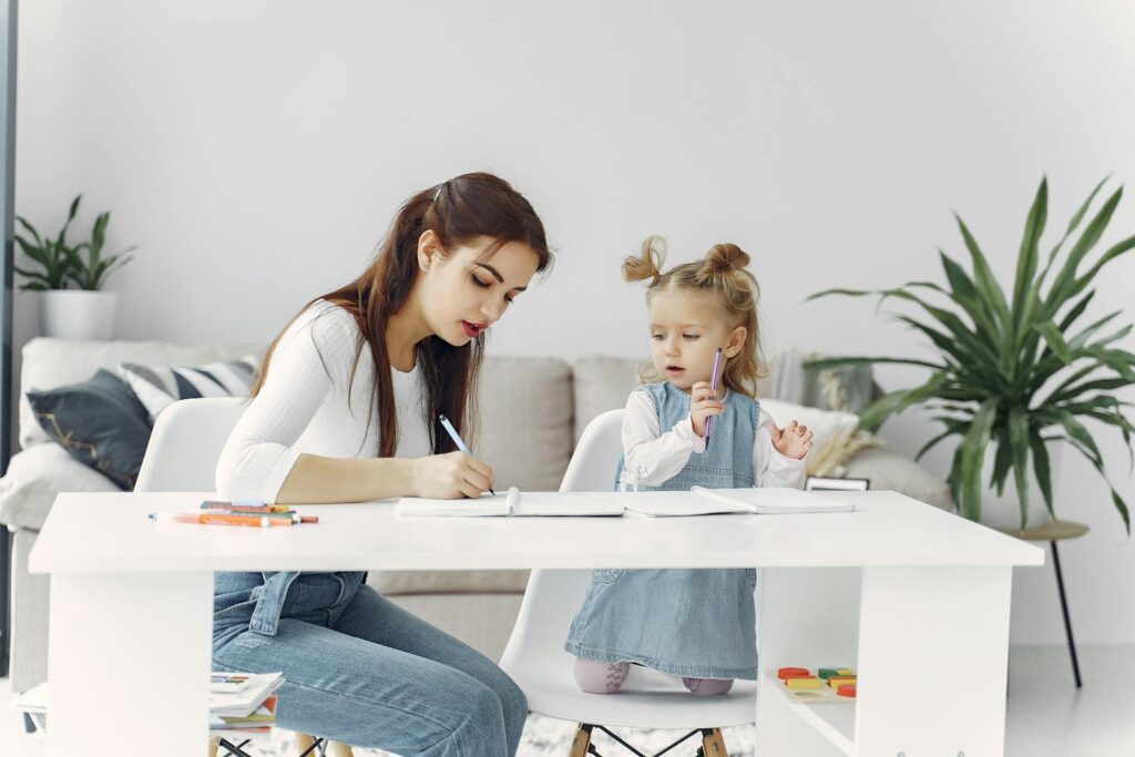 A mother and daughter enjoying a bonding moment while doing homework together at home.