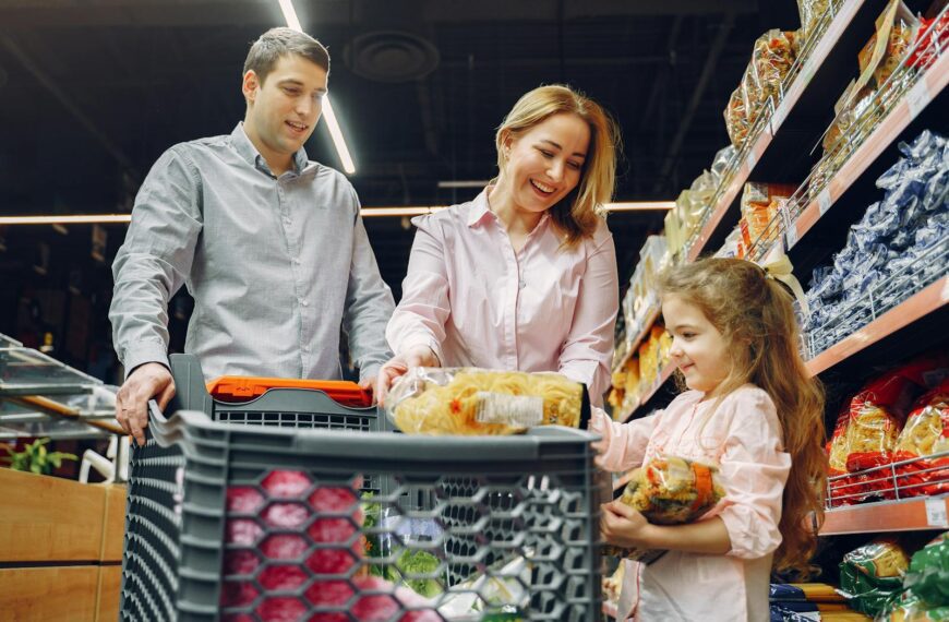 A joyful family of three shopping together in a supermarket, creating a memorable experience.