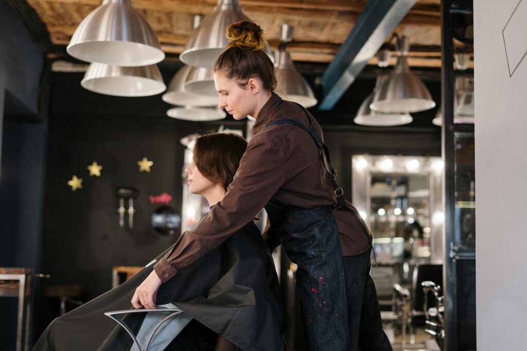 Hairdresser styling a client's hair in a contemporary salon setting.