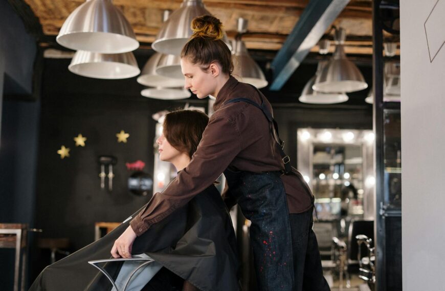 Hairdresser styling a client's hair in a contemporary salon setting.