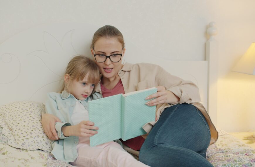 Woman reading a book to a young girl.