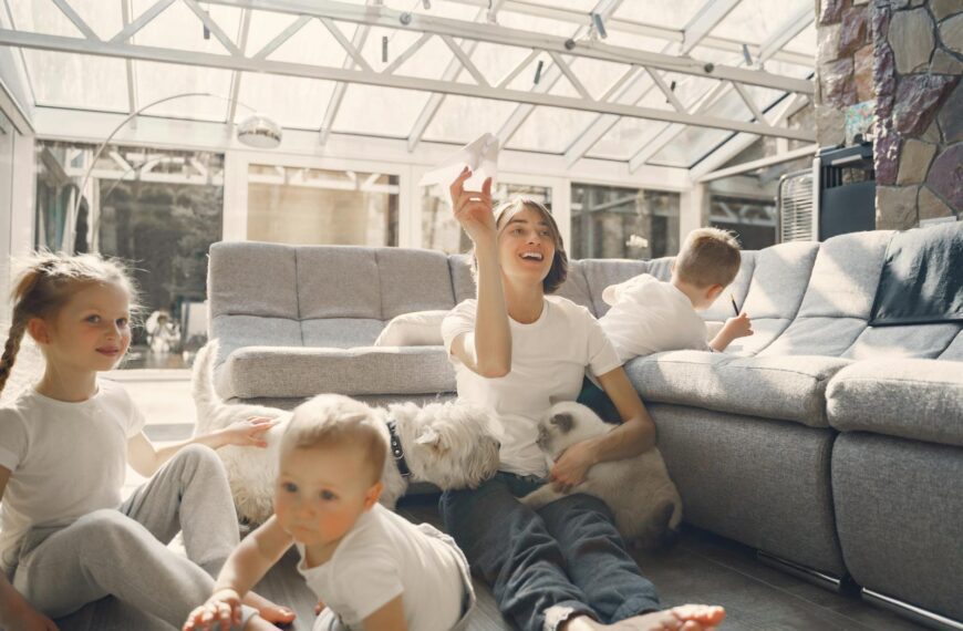A joyful family with children and pets having fun indoors, enjoying leisure time together.