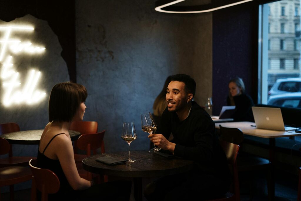 Couple enjoying a romantic evening with wine at a stylish bistro.