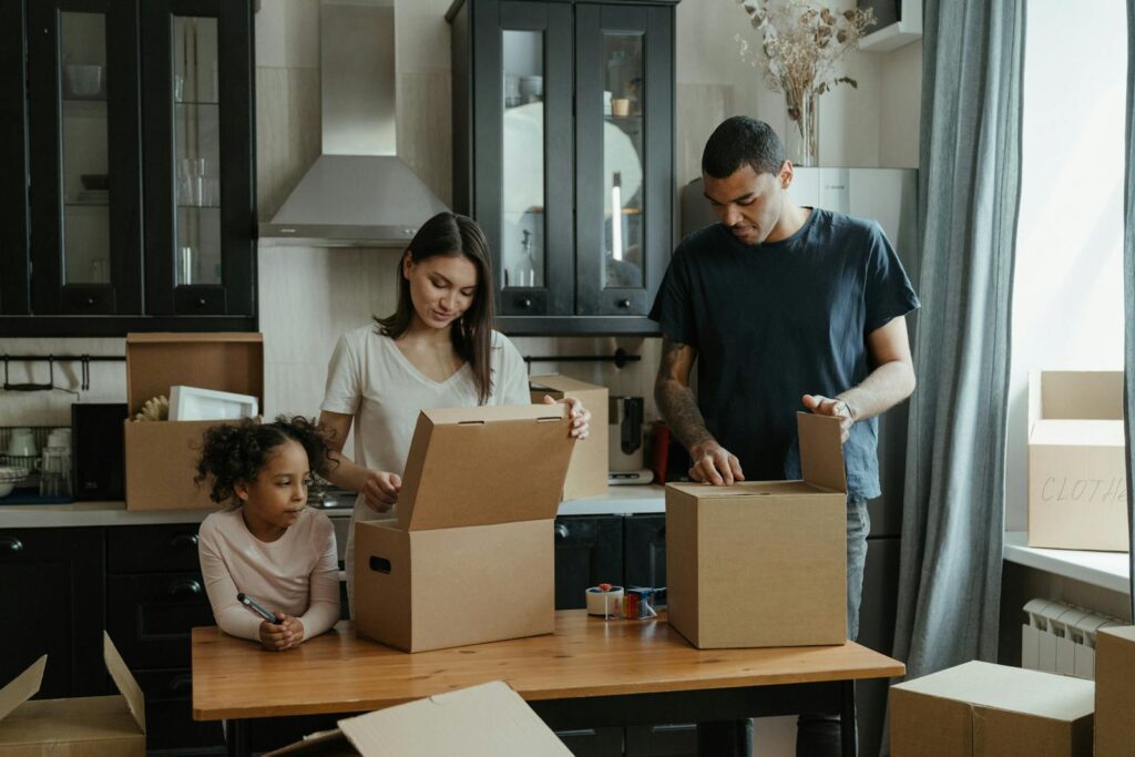 Family unpacking boxes in their new kitchen, enjoying a fresh start in a cozy home.