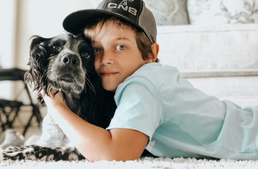 A young boy laying on the floor with a dog