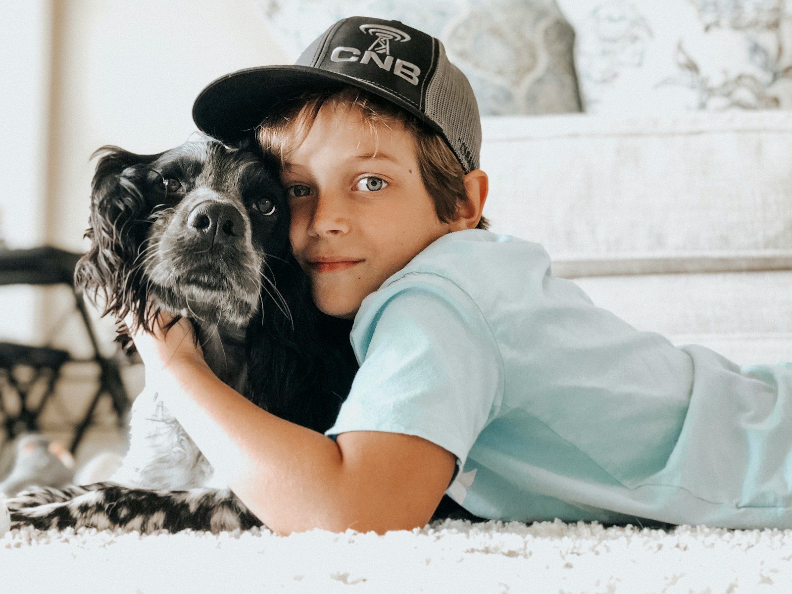 A young boy laying on the floor with a dog