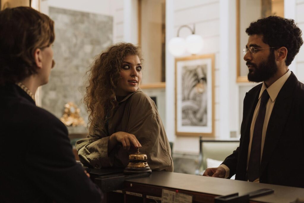 Guests interacting at a luxurious hotel reception desk, emphasizing hospitality and service.
