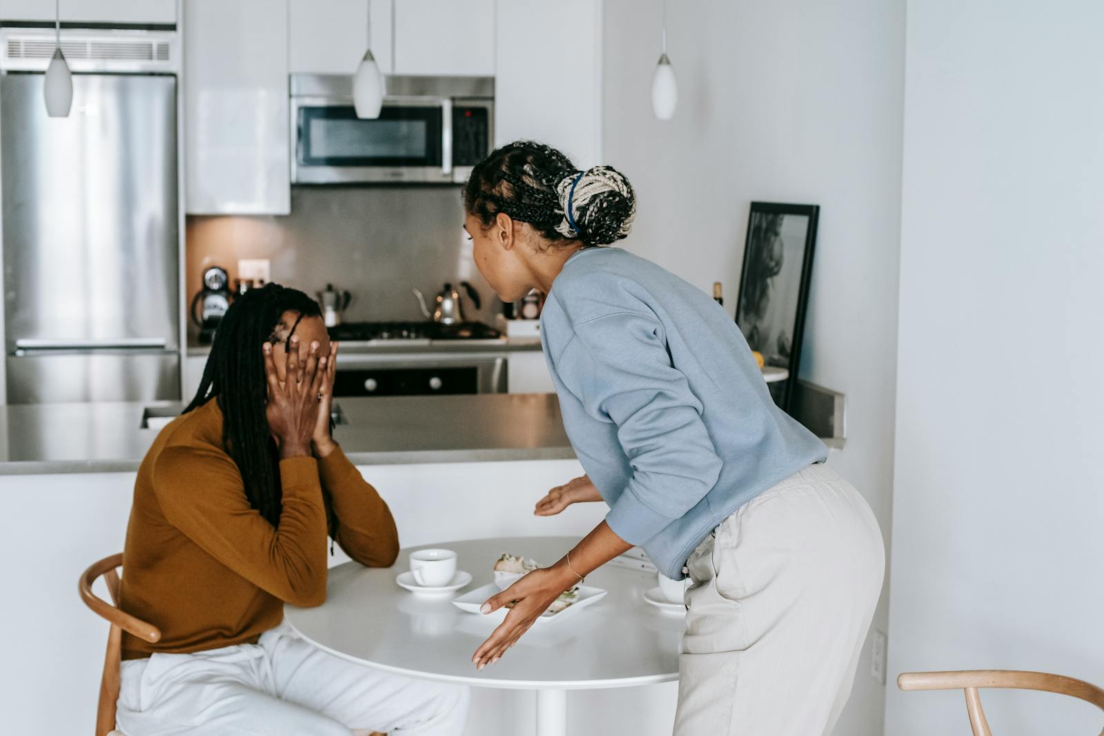 A young couple engaged in an intense discussion in a modern kitchen setting, showcasing emotional expression.