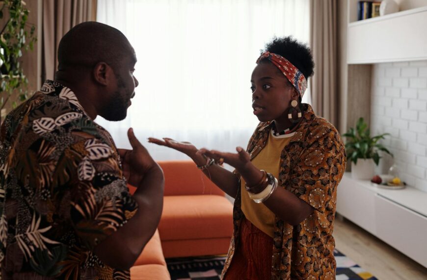 A couple arguing passionately in their living room, expressing emotions and gestures.