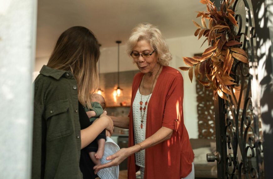 A tender moment of a grandmother greeting a family with a newborn baby during a holiday gathering.