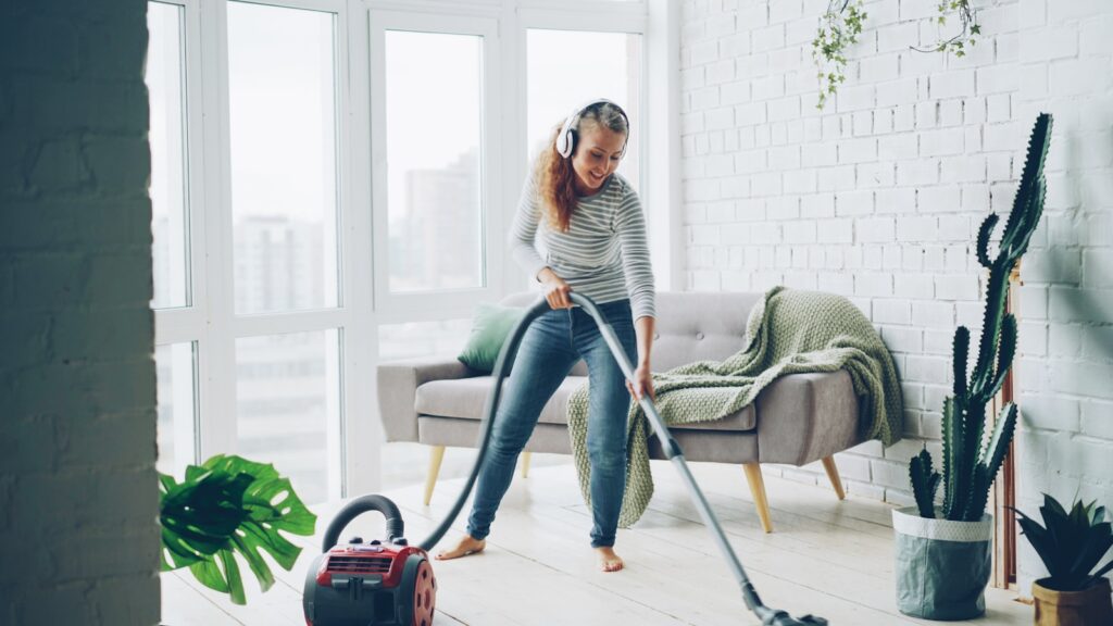 Woman vacuuming floor while listening to music.