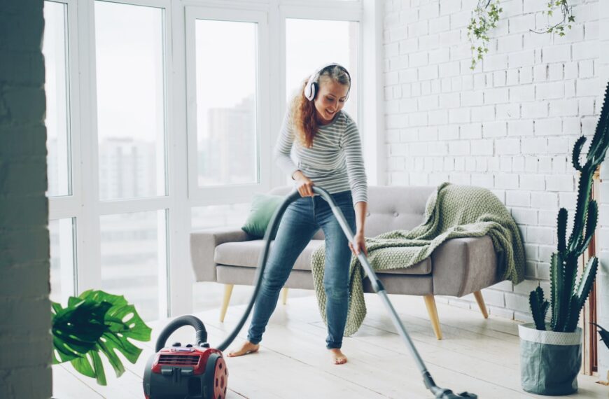 Woman vacuuming floor while listening to music.