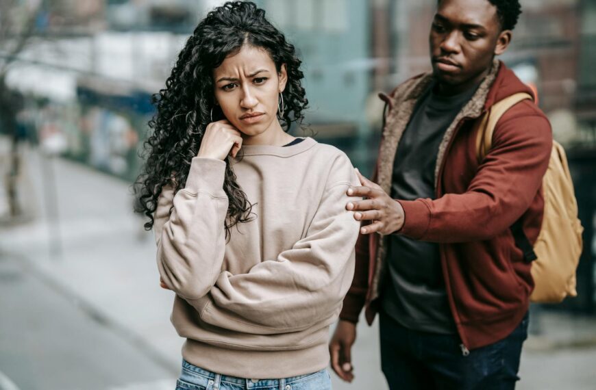 A young couple having a disagreement outdoors, displaying emotions and tension.