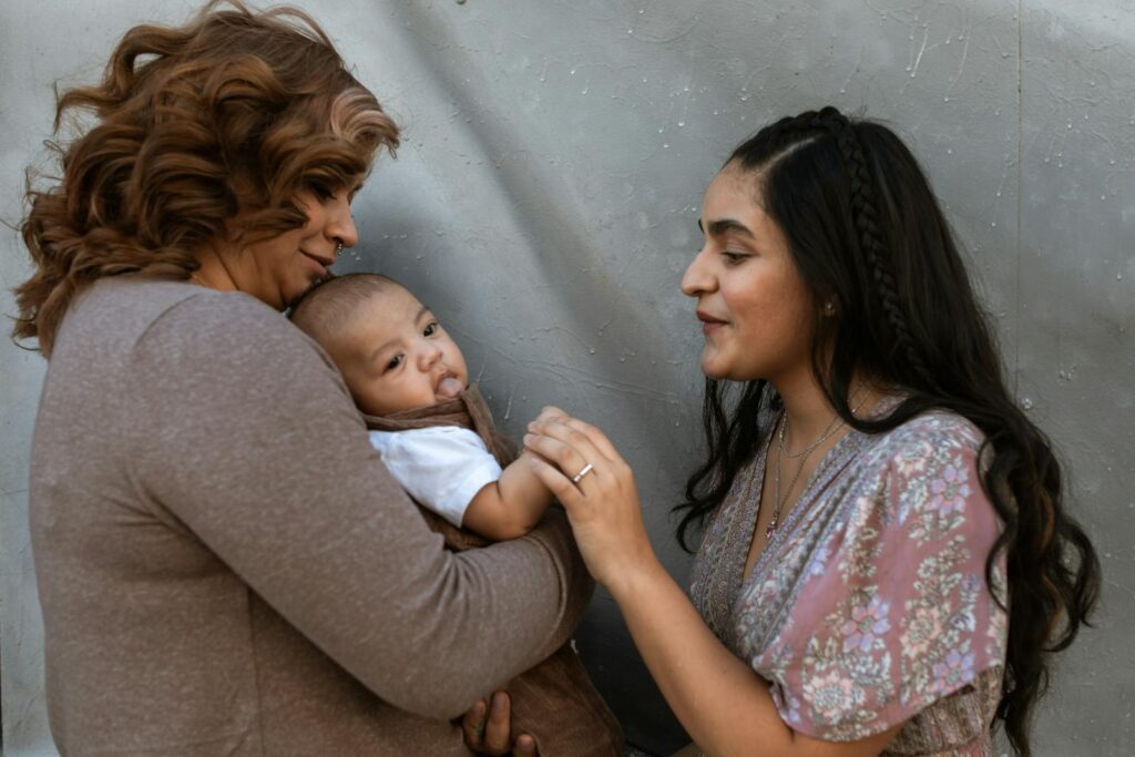 Warm family interaction with a mother and her baby, captured indoors, showcasing happiness and love.