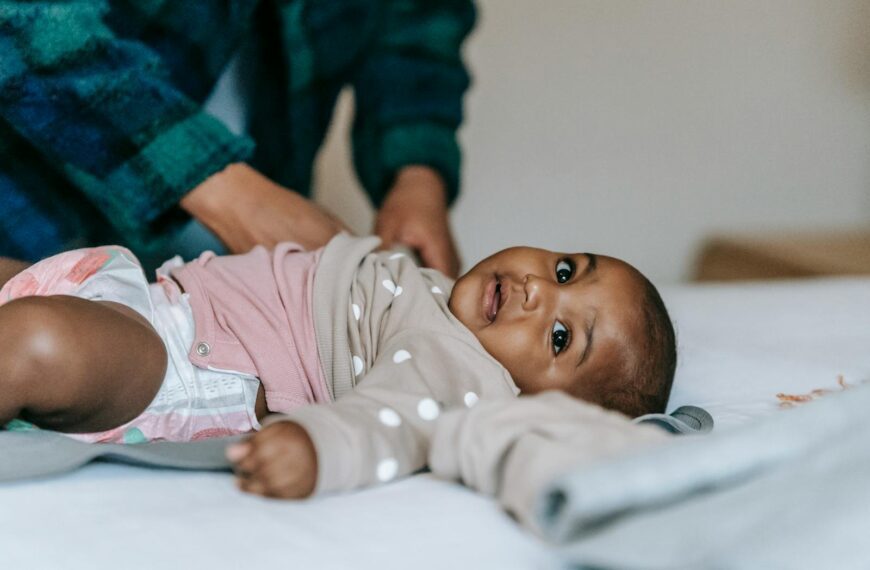 Cute baby in diaper on a bed, receiving care. Perfect for childcare themes.