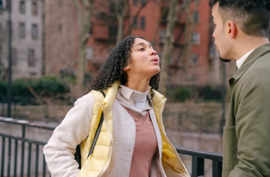 A young couple having an intense conversation outdoors, showcasing a moment of conflict.