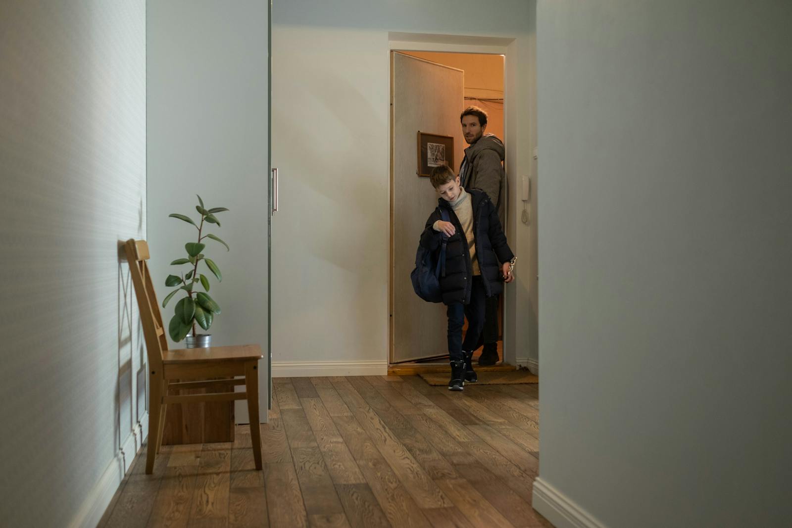Father and son entering their cozy apartment, highlighting family togetherness and home comfort.