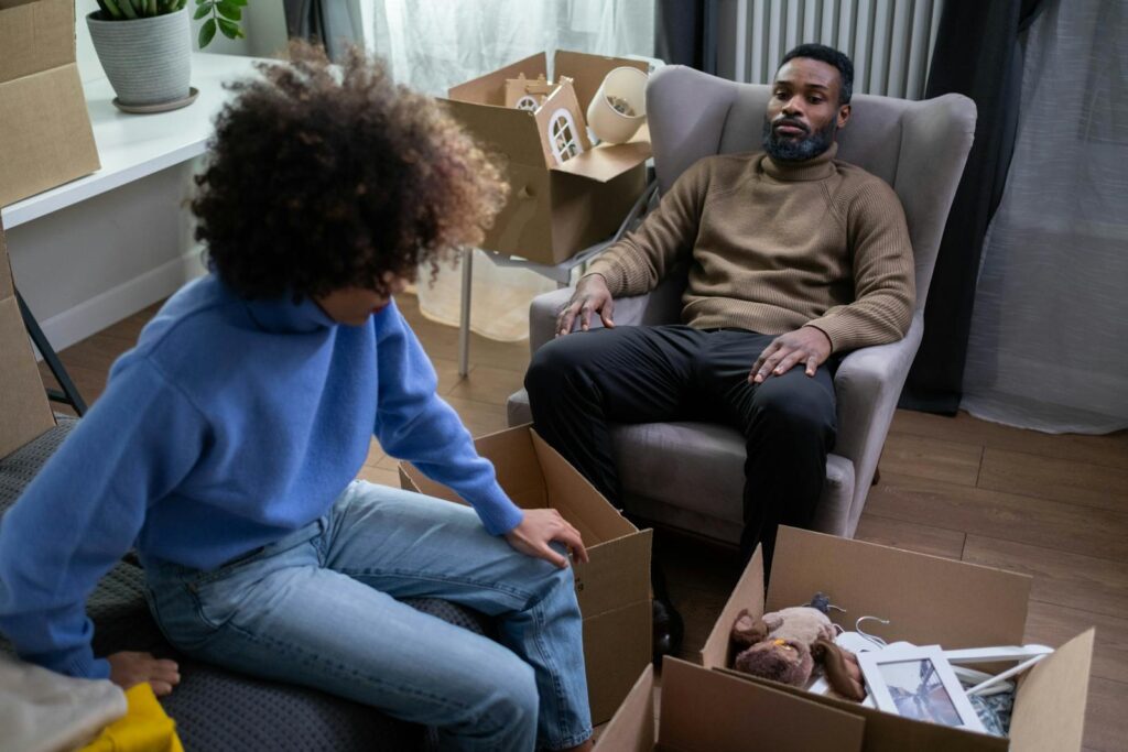 A couple in a cozy living room packing boxes during a move.