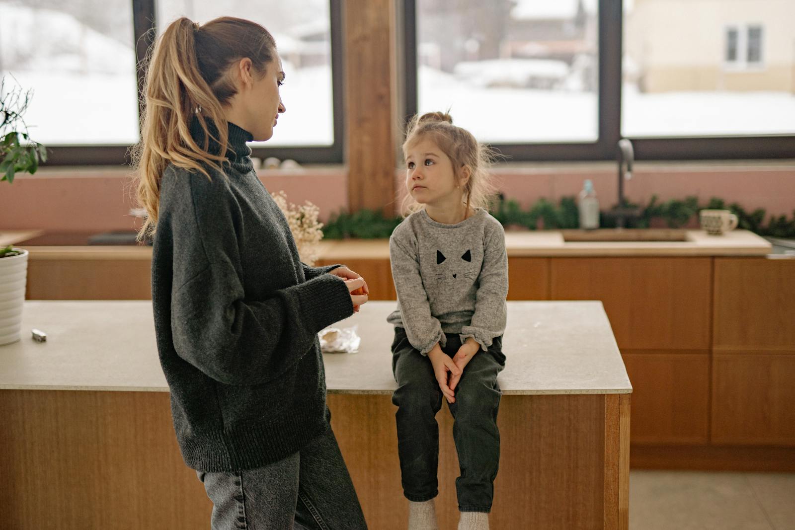 Family scene with mother and daughter in a warm, cozy kitchen setting.