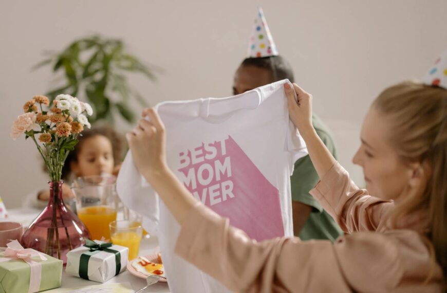 A joyful indoor Mother's Day celebration featuring a family with a 'Best Mom Ever' shirt.