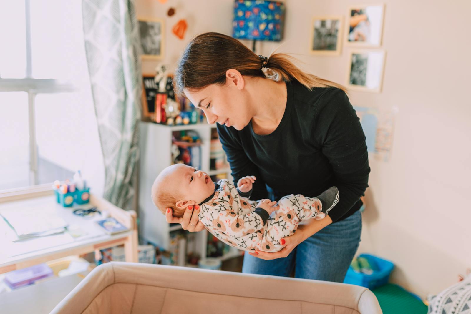 A mother lovingly holds her newborn baby in a cozy nursery, symbolizing motherhood and togetherness.