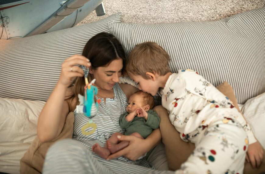 Mother with her newborn and son in a cozy setting, sharing affection.