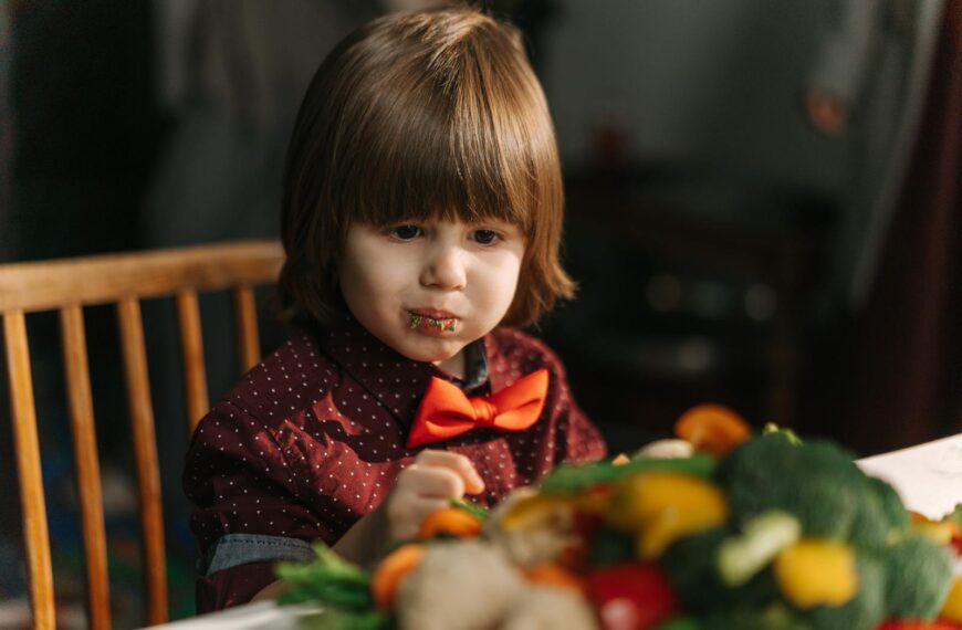 Adorable child enjoying fresh vegetables at the dinner table.