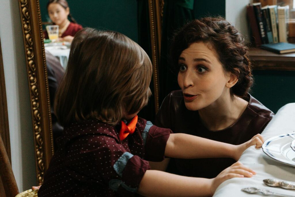 A candid moment at dinner with a mother and child sharing an animated conversation, reflecting family warmth.