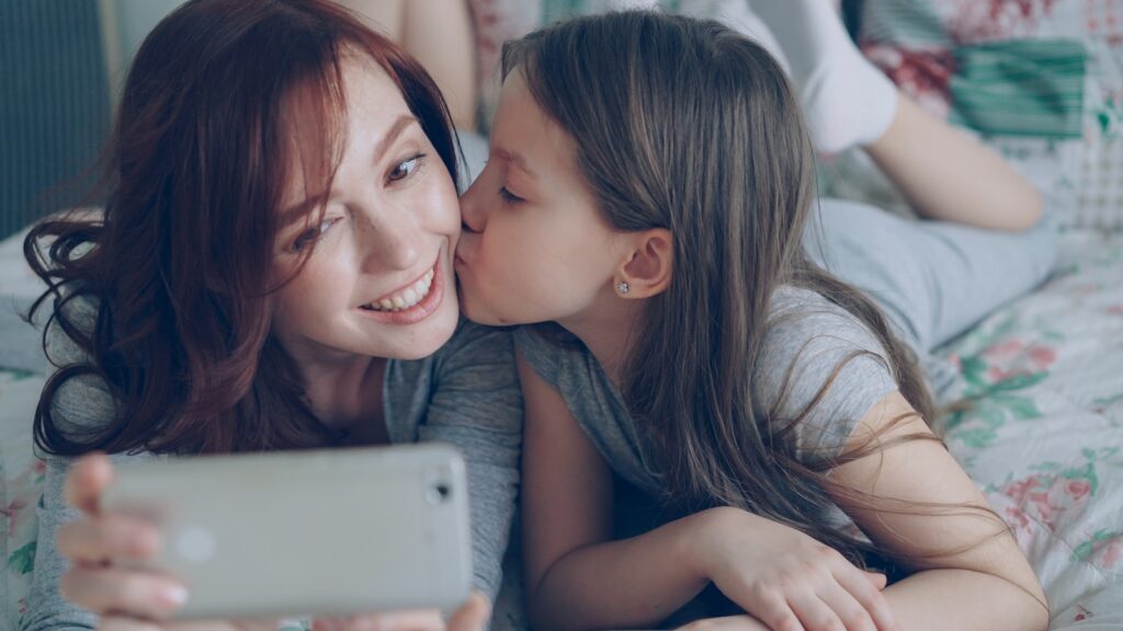 Mother and daughter are taking a selfie.