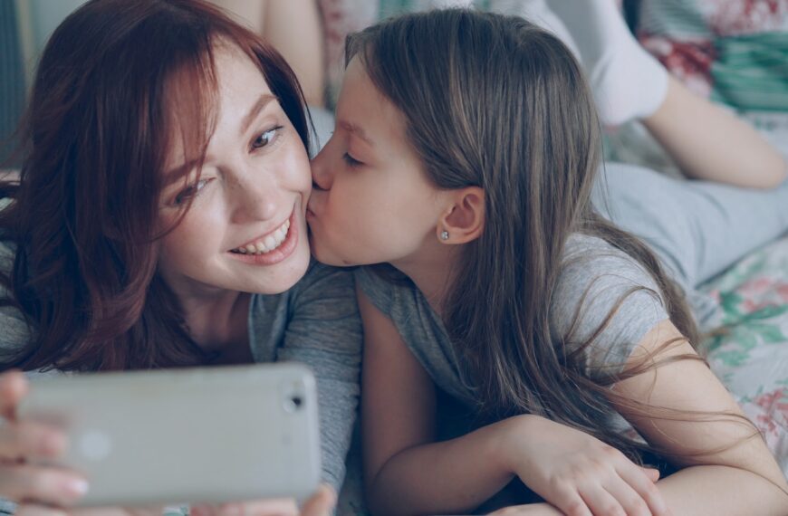 Mother and daughter are taking a selfie.