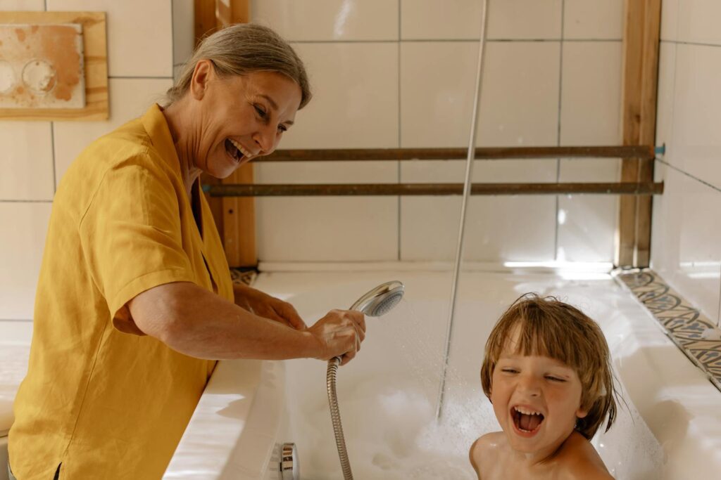 A happy grandmother and her grandson enjoying bath time, creating playful and cheerful memories.