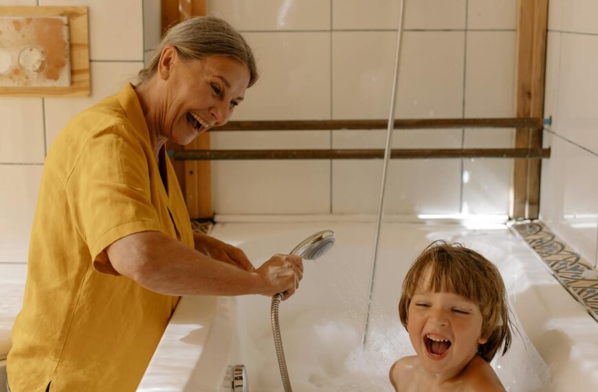 A happy grandmother and her grandson enjoying bath time, creating playful and cheerful memories.