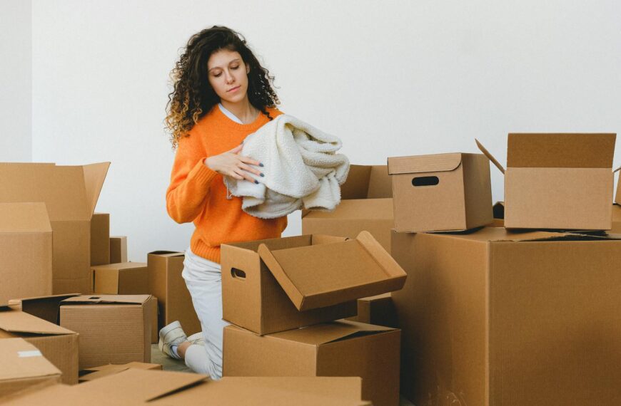 Woman sorting boxes for moving or organizing at home. Indoor setting.