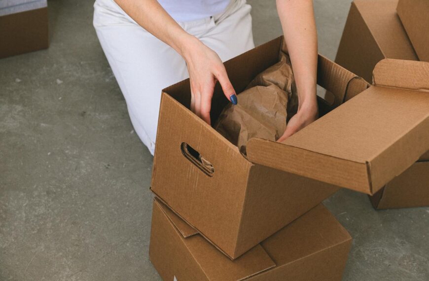 A woman organizing cardboard boxes while preparing to move into a new apartment.