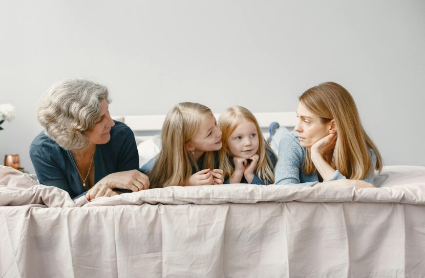 A happy family scene with grandmother, mother, and daughters bonding indoors.