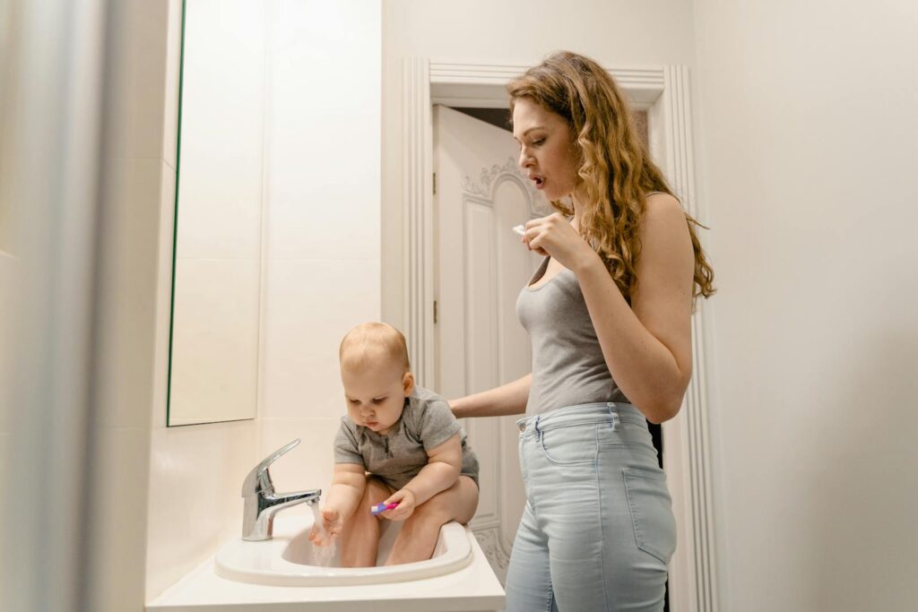 Mother and child bonding over morning routine in bathroom, brushing teeth together.