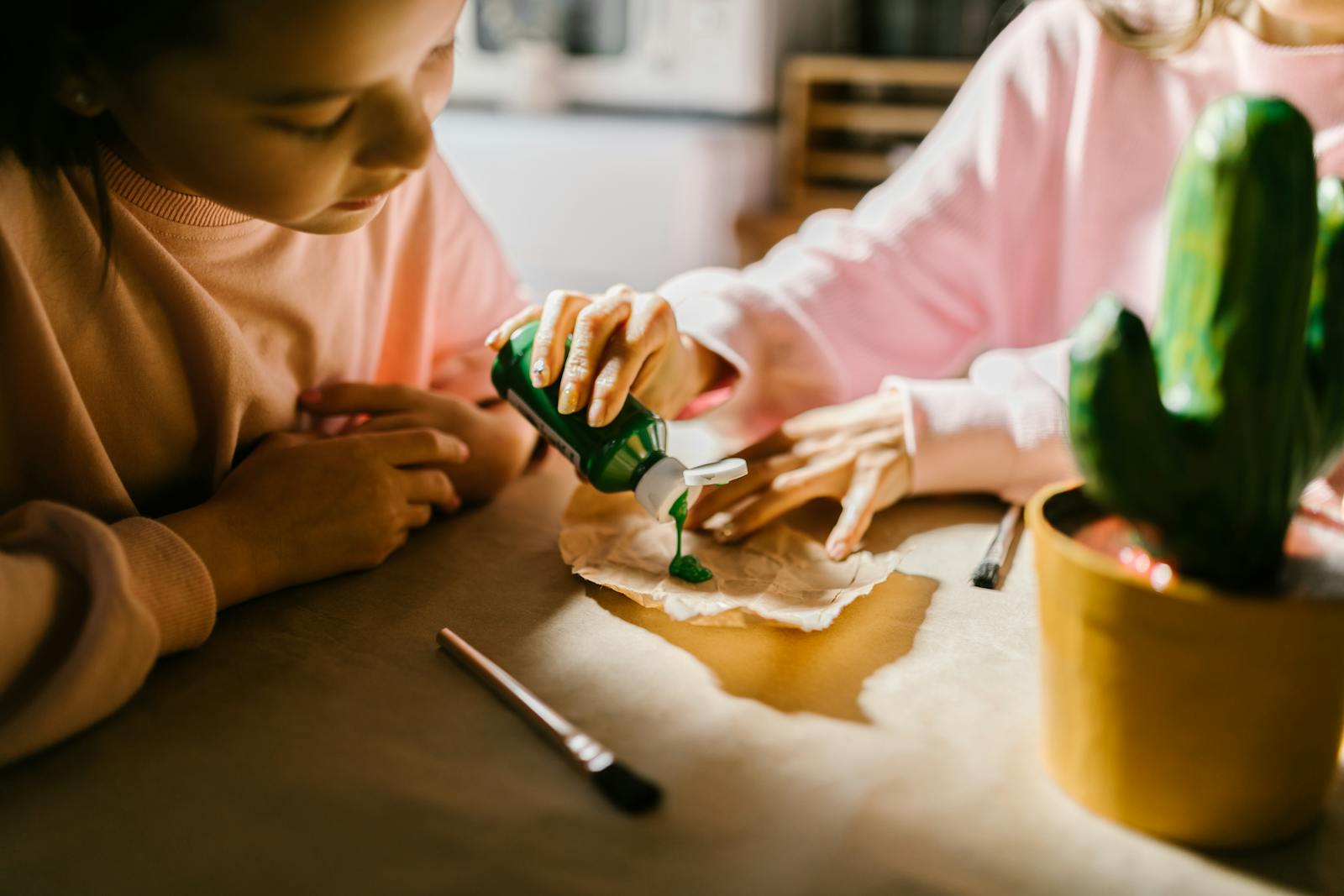 Children enjoying a crafting project indoors with paint and creativity.