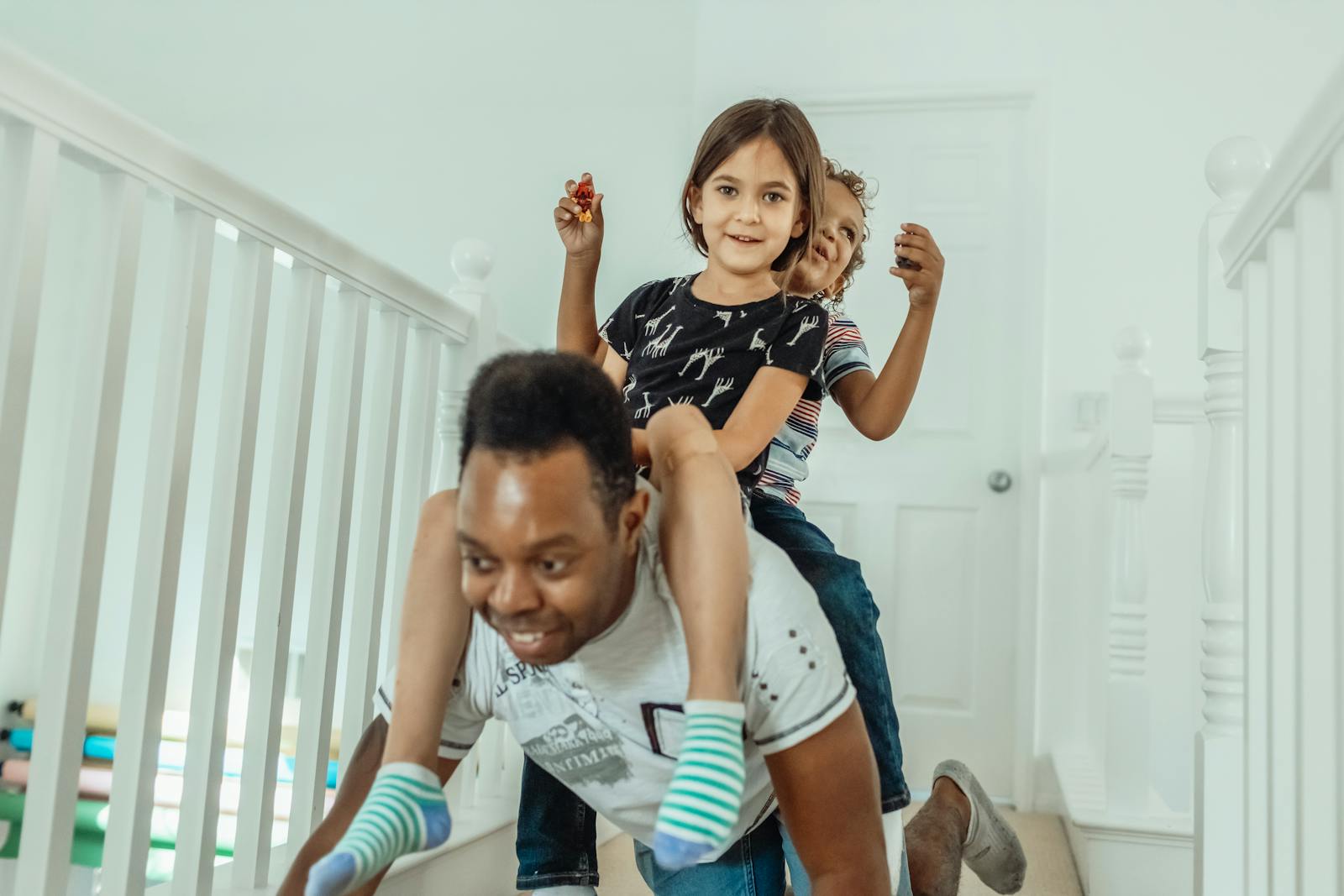 Father playing with children in hallway, piggyback ride fun.