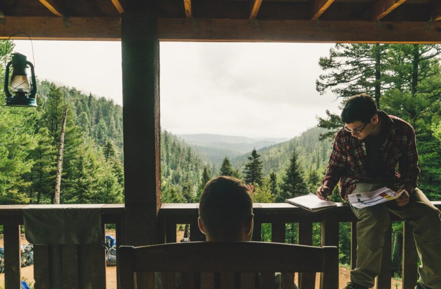 man holding book near tree during daytime