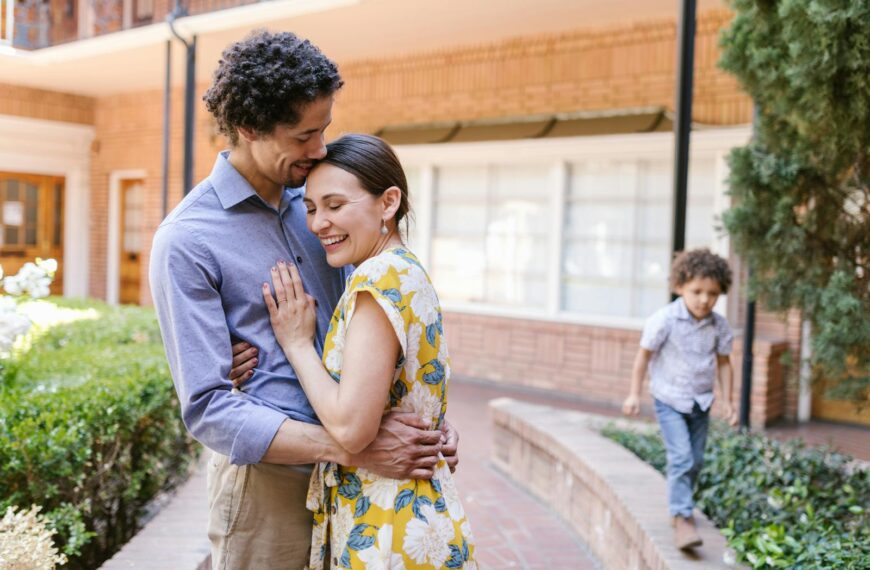 A joyful family embracing outdoors, capturing warmth and togetherness with a young child nearby.