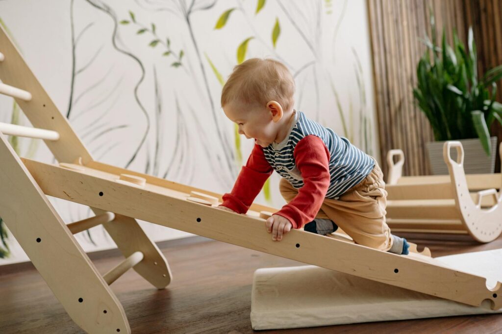 A young child enjoys climbing a wooden toy ladder indoors, promoting playtime and activity.