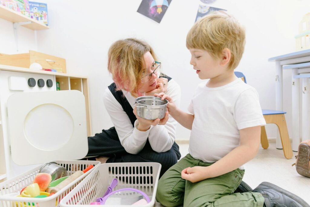 Child and teacher playing together in a bright classroom, fostering learning and fun.