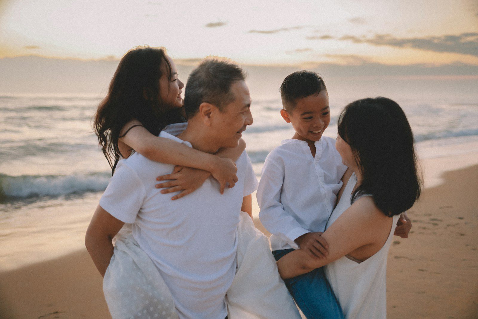 Family enjoying a beach walk at sunset