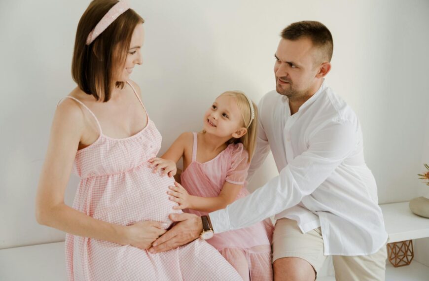 Happy family cherishing a special moment with the expectant mother indoors.